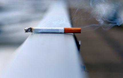Image of cigarette burning on railing