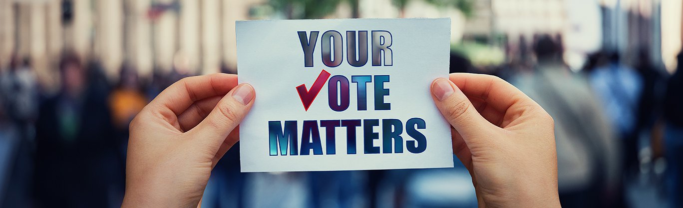 Person holding a card that reads your vote matters